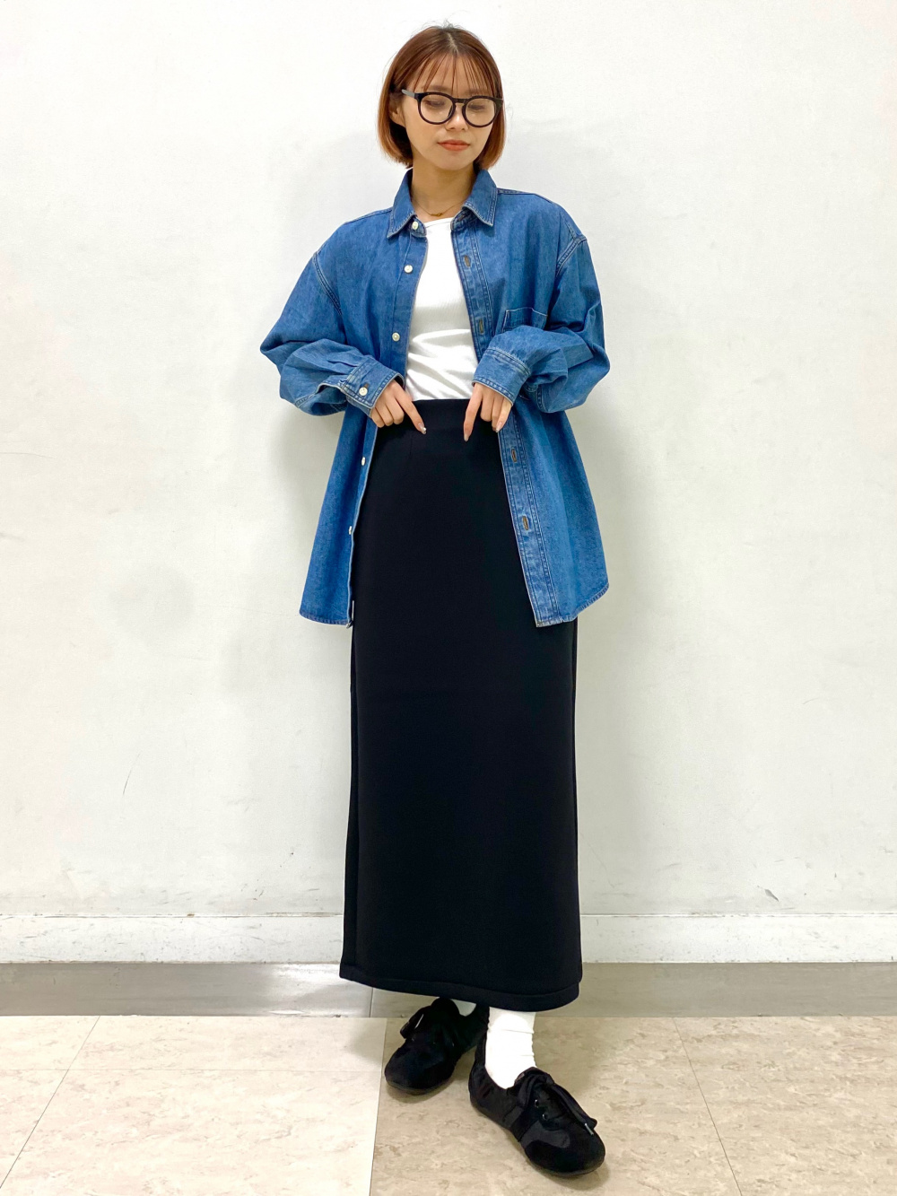 Blue denim overshirt with a white tank and black maxi skirt