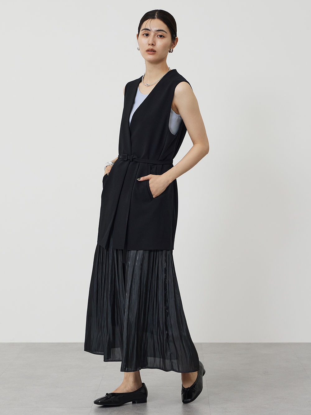 黒のジレにプリーツスカート合わせたカジュアルコーデ