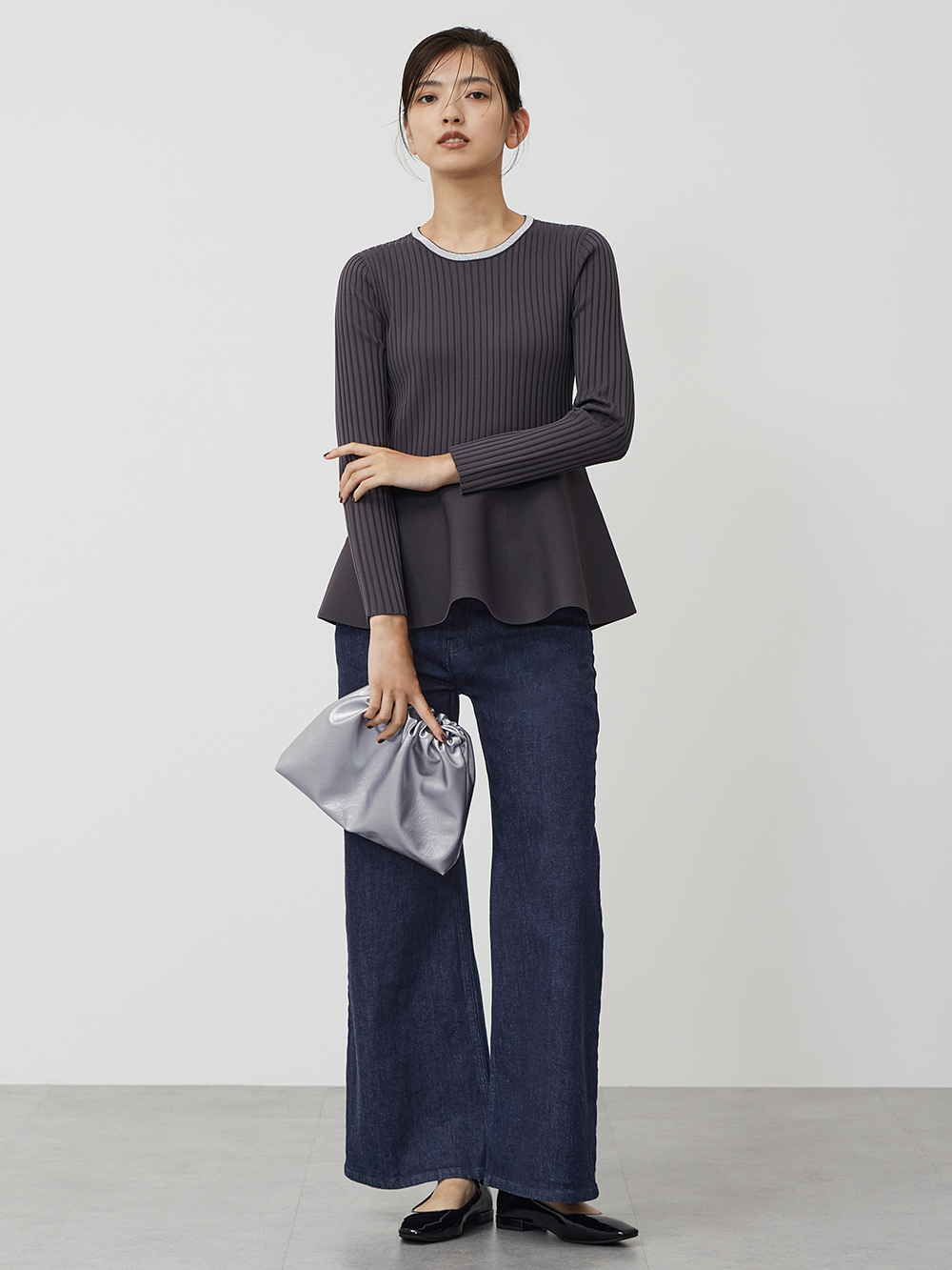 ペプラムシルエットのニットとデニムパンツのコーデ