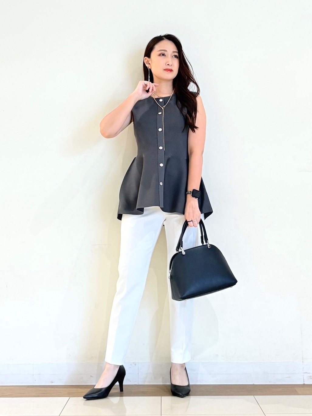 ペプラムシルエットのノースリーブニットに細身のパンツを合わせた春夏コーデ