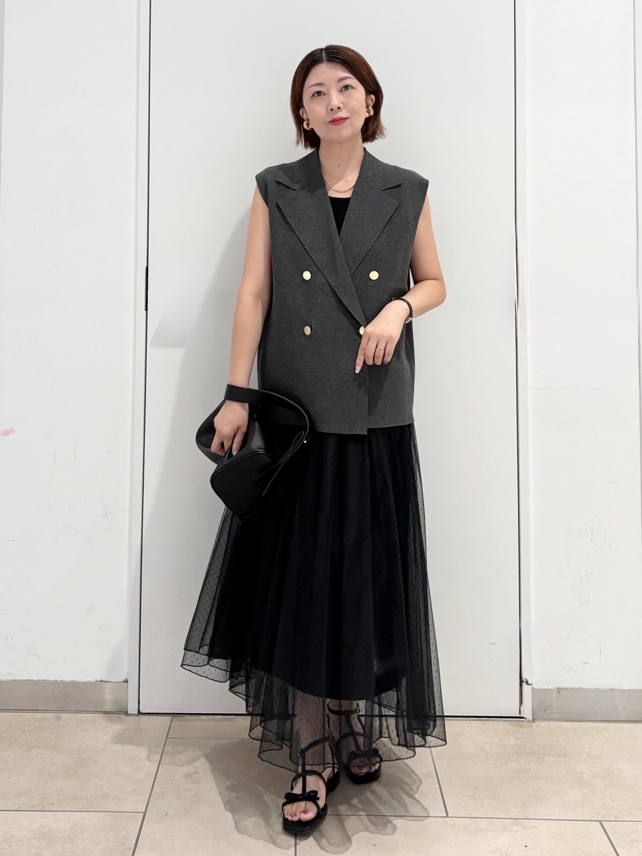ダークグレーのベストに、黒のチュールスカートを合わせた夏のきちんと服