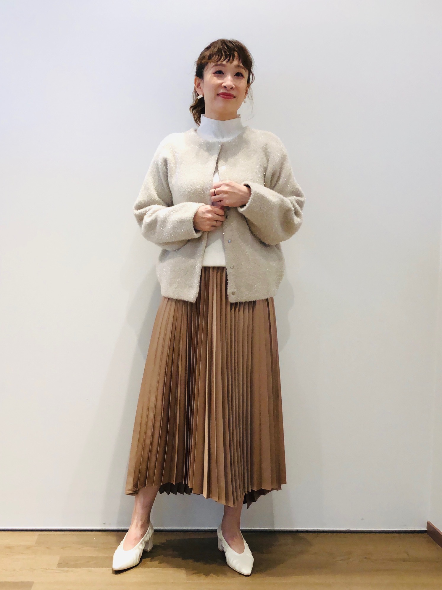 ニットカーディガンとツヤのあるサテン素材のスカートのコーデ