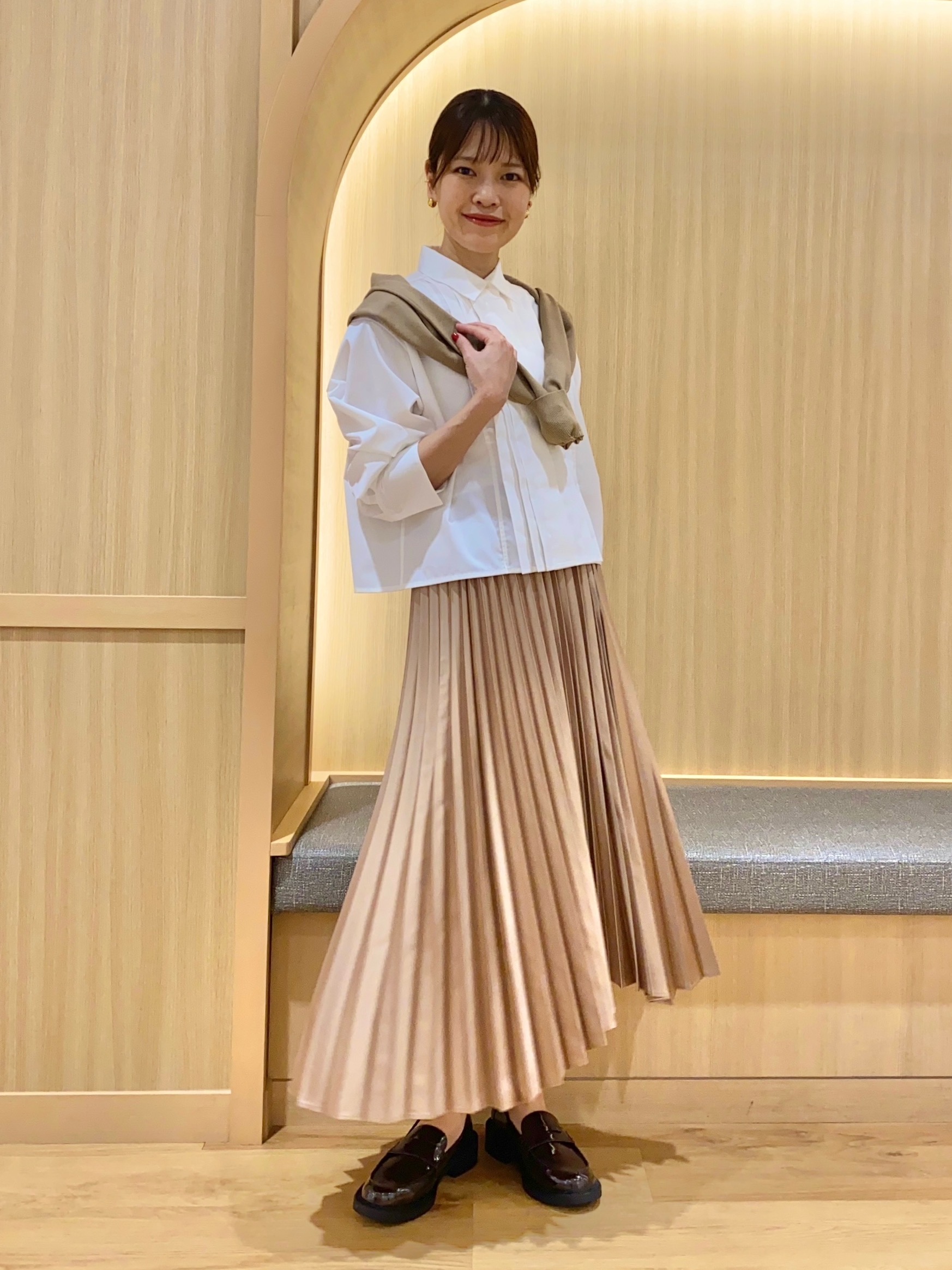 白シャツにサテンのプリーツスカートを合わせたコーデ