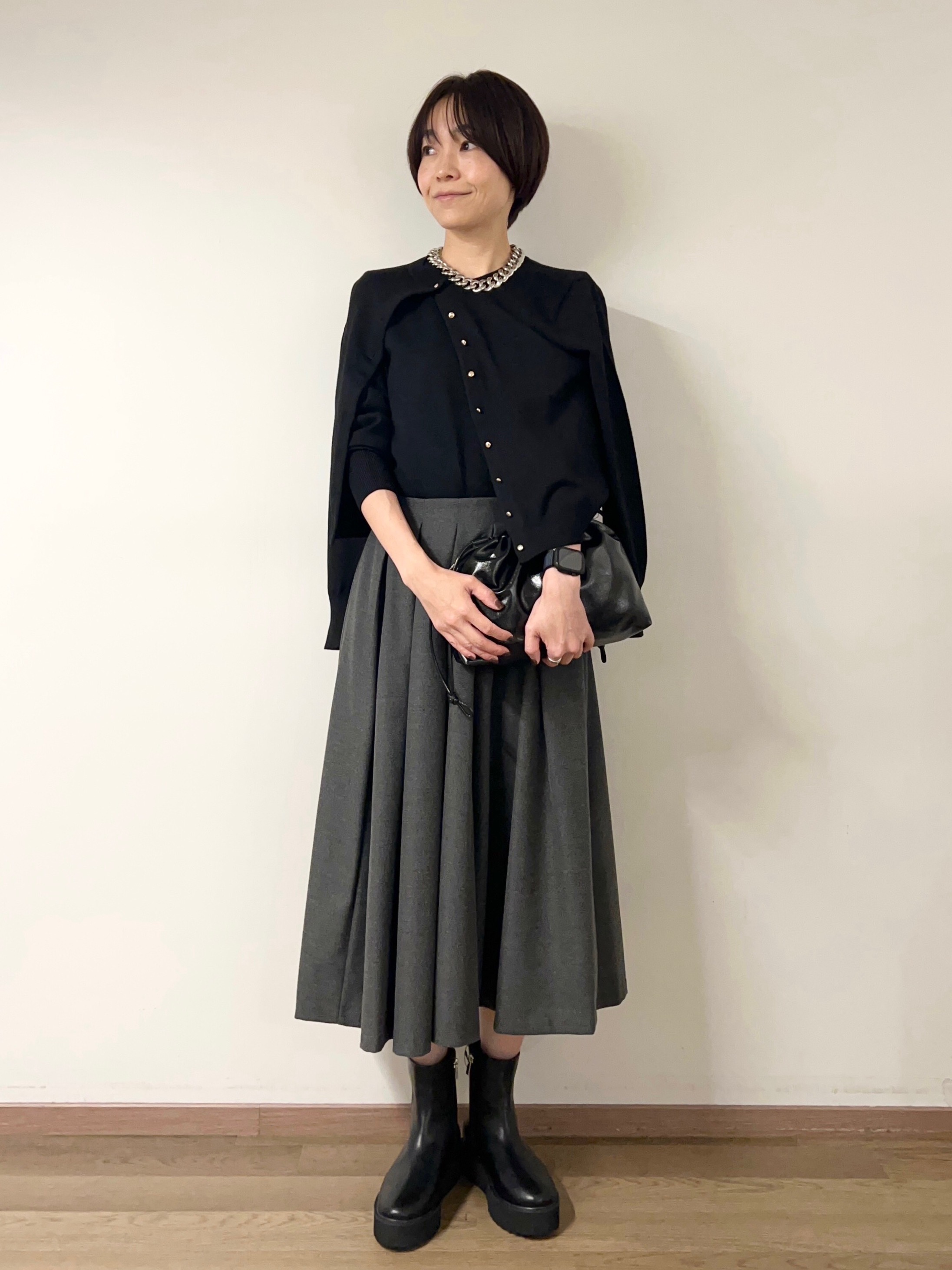 ブラックのフレアスカートとベージュのトップスのコーデ