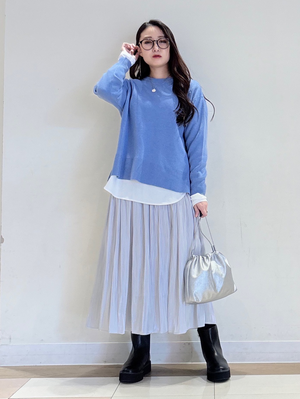 ライトグレーのスカートにブルーのニットを合わせたコーデ