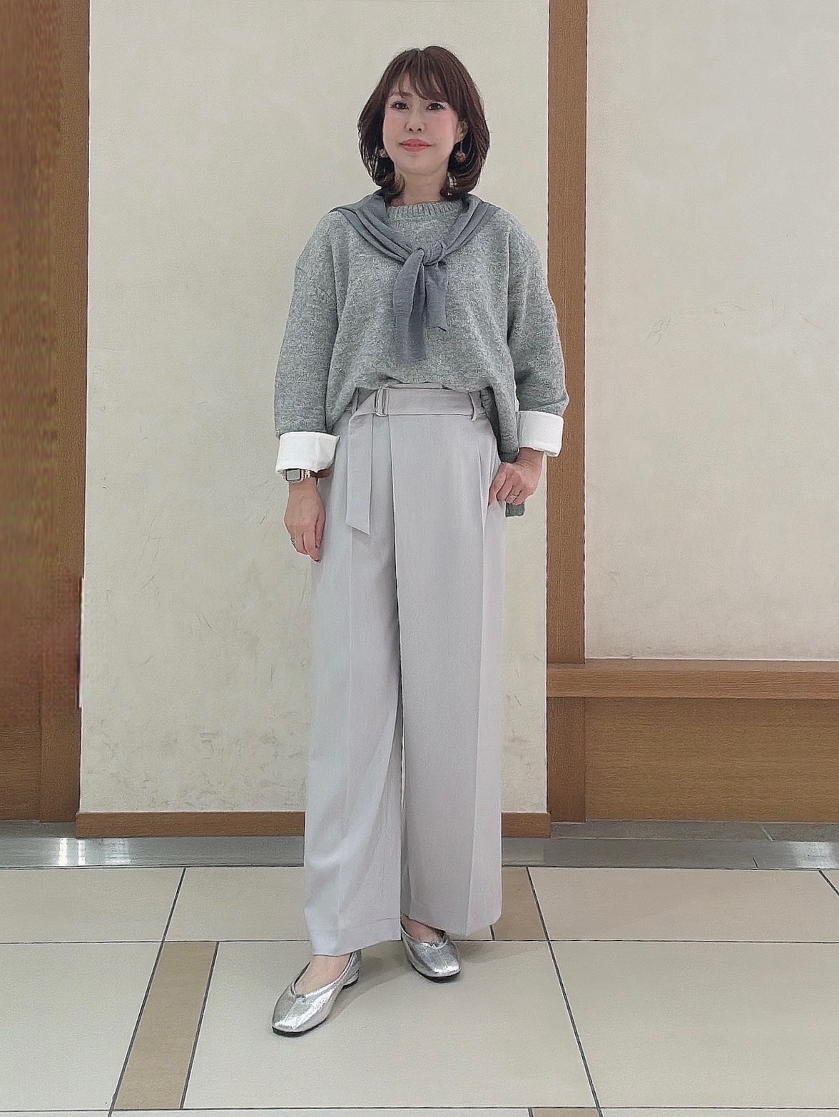 カフス付きカットソーにグレーのニットをレイヤードしたコーデ