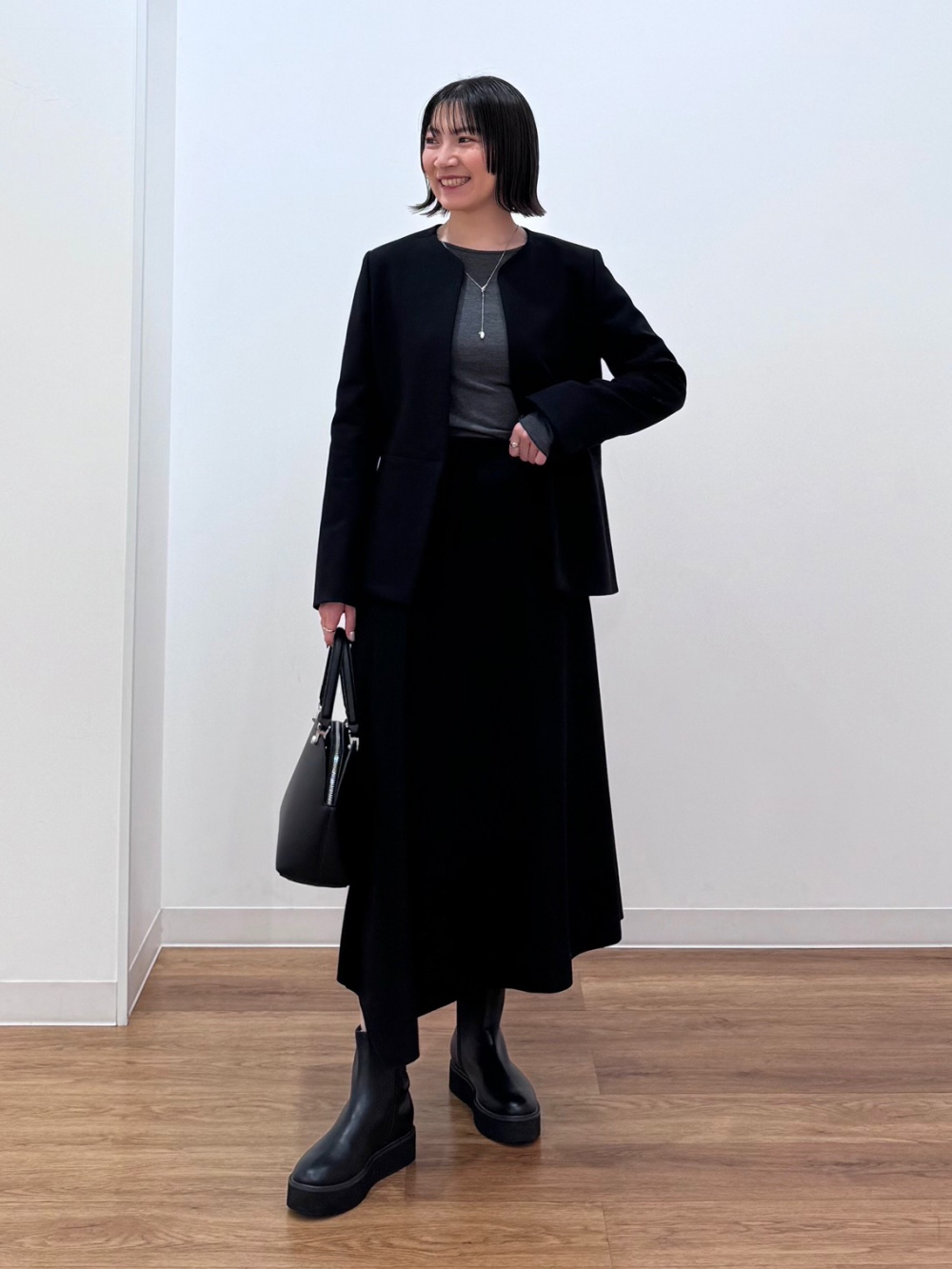 スタンドカラーパデッドブルゾン、タックボリュームスカート」の着用