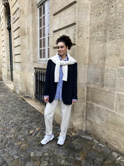 Premium Photo  A woman in a white top and blue leggings stands in a street.