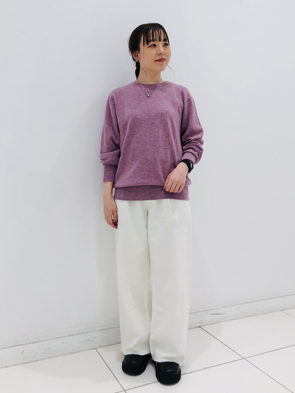 カシミヤクルーネックセーター、ドレープデニムタックパンツ」の着用