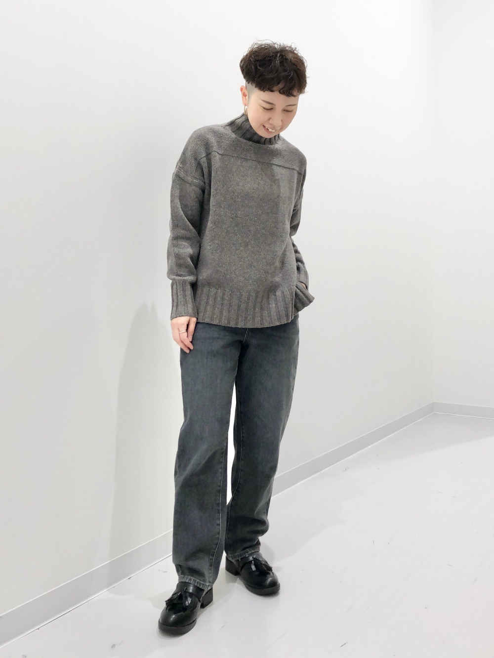プレミアムラムハイネックセーター、タックテーパードジーンズ」の着用