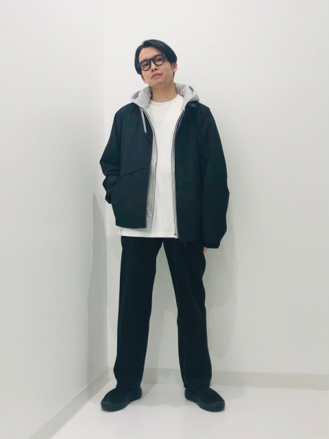 黒のスタンドカラーブルゾンに白Tとグレーパーカーを合わせたレイヤードコーディネート