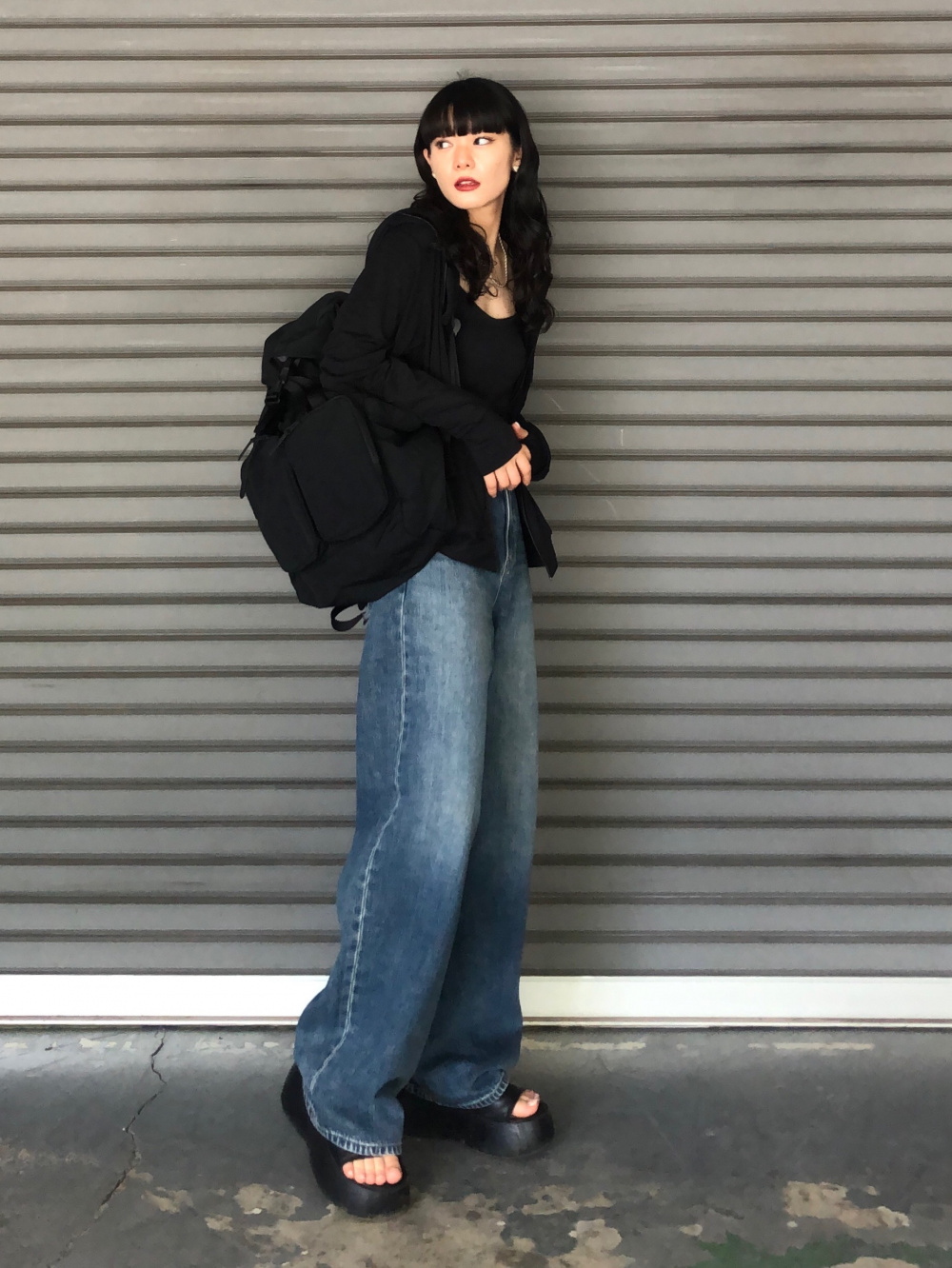 ニットVネックベスト、ワイドストレートジーンズ」の着用