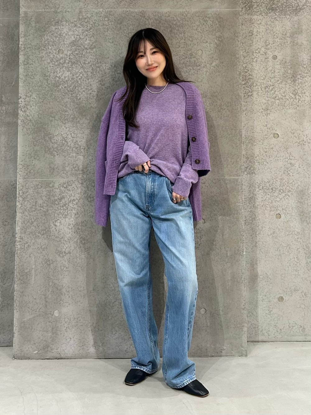 カシミヤクルーネックセーター、ドレープデニムタックパンツ」の着用