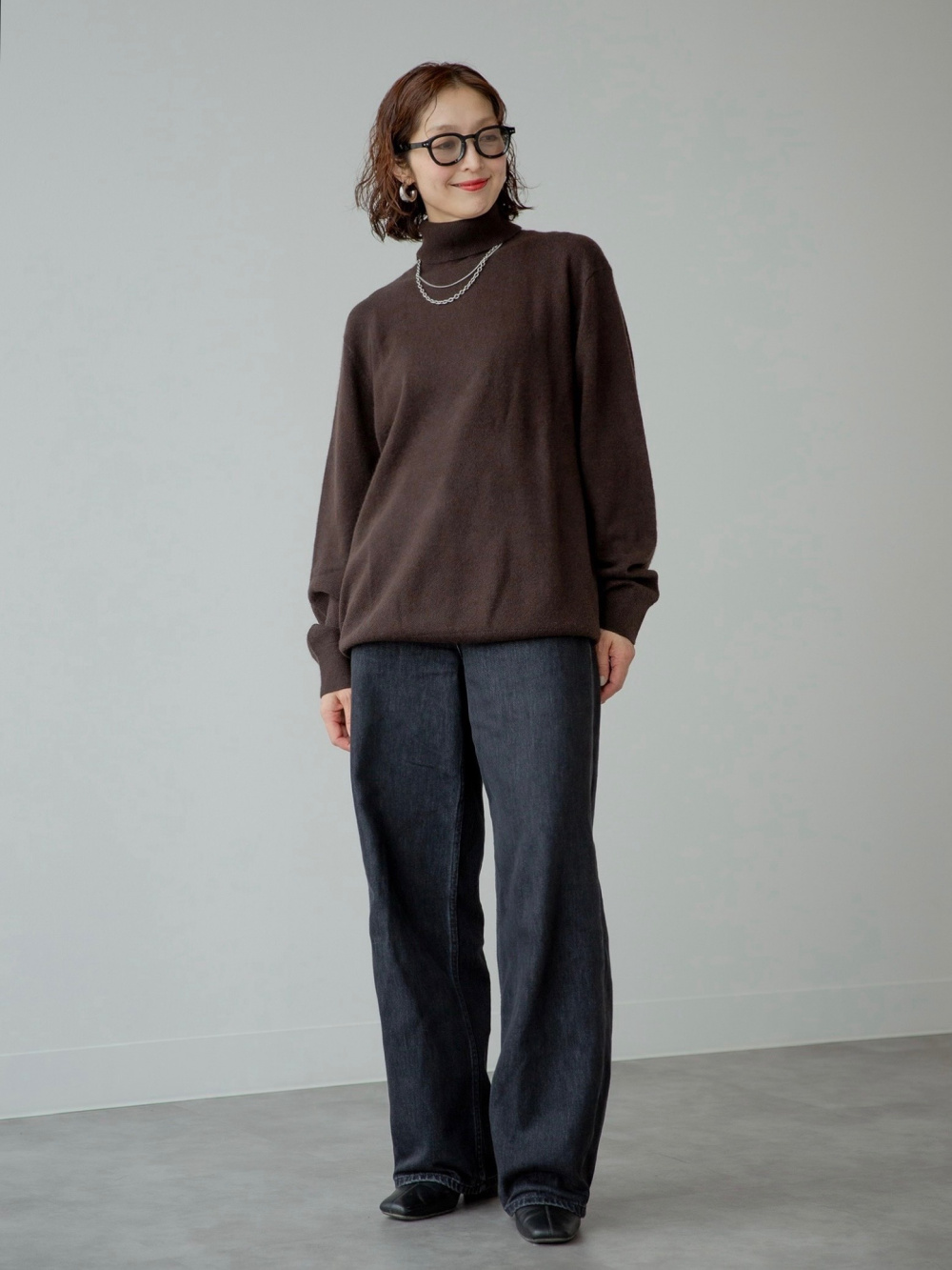 カシミヤタートルネックセーター、バギーカーブジーンズ」の着用