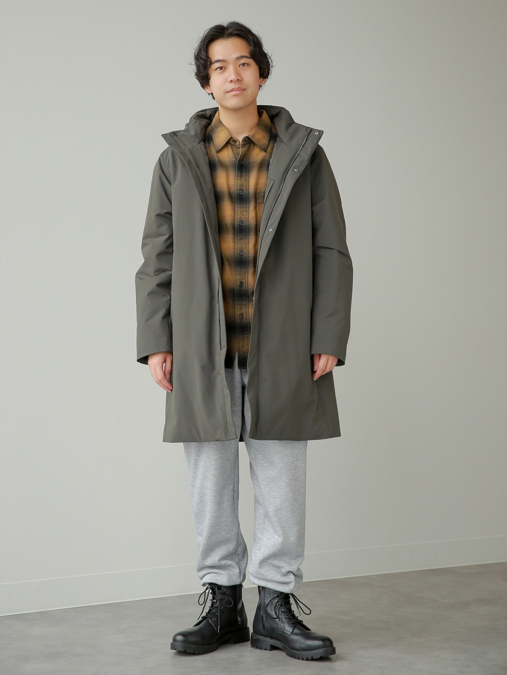 トレンチコートリラックスフィット、フランネルチェックシャツ」の着用