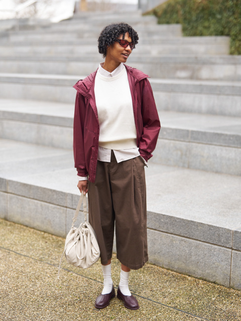 la mannequin porte une jupe-culotte marron avec un haut blanc et une veste bordeaux