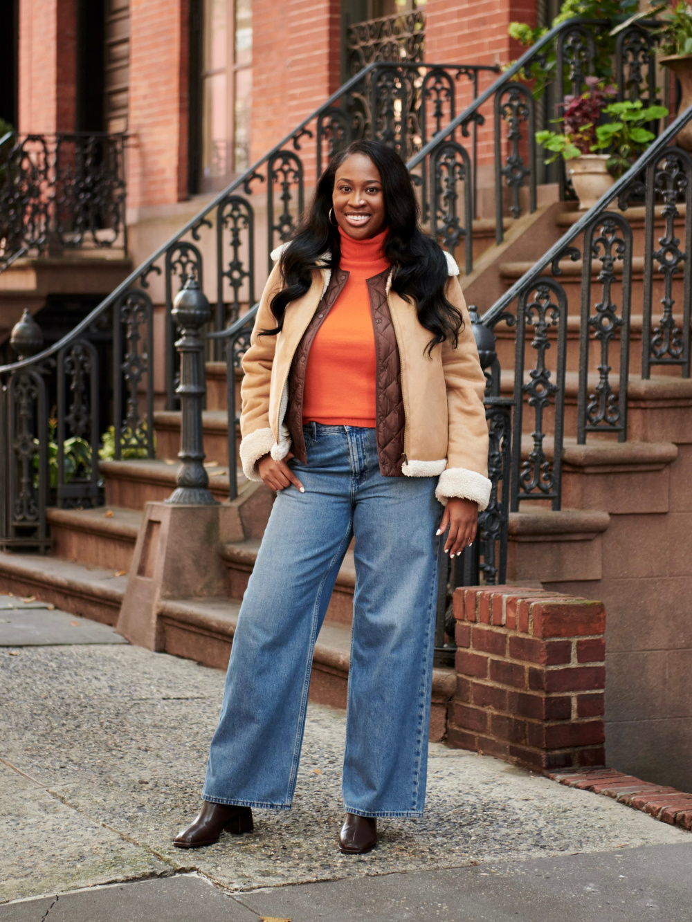 Julie Pelipas wears black jacket, wide leg denim jeans outside